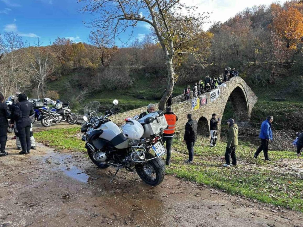 Η Καλαμπάκα φιλοξένησε την τρίτη χρονιά της Χειμερινής Συγκέντρωσςη της ΕΛ.ΜΟΤ.Ο, με τους συμμετέχοντες να αγνοούν βροχές, κρύο και δυσκολίες, γεμίζοντας την περιοχή με μοτοσυκλέτες, χαμόγελα και ταξιδιωτική διάθεση. Το Σαββατοκύριακο που μας πέρασε, πραγματοποιήθηκε στην Καλαμπάκα η 3η Χειμερινή Συγκέντρωση Μοτοσυκλέτας της ΕΛ.ΜΟΤ.Ο, μια μεγάλη γιορτή της μοτοσυκλετιστικής κοινότητας που στέφθηκε με επιτυχία παρά τις απαιτητικές καιρικές συνθήκες. Οι συμμετέχοντες αποχώρησαν με θετικές εντυπώσεις, τόσο για την οργάνωση όσο και τη φιλοξενία της τοπικής κοινωνίας. Από την πρώτη στιγμή, ο Δήμος Μετεώρων και η ΜΟ.ΛΕ.Κ (Μοτοσυκλετιστική Λέσχη Καλαμπάκας) στήριξαν ενεργά την εκδήλωση, προσφέροντας ουσιαστική βοήθεια και συνοδεύοντας τα τρία οργανωμένα εκδρομικά της διοργάνωσης. Τα μέλη της λέσχης ανέλαβαν την πλοήγηση των διαδρομών, παρουσιάζοντας στους συμμετέχοντες όμορφες και λιγότερο γνωστές γωνιές της περιοχής. Ρεκόρ συμμετοχής φαίνεται πως σημείωσε η διαδρομή προς τη Λίμνη Λογγά – Παραδοσιακό Γεφύρι Ψύρρα – Μετέωρα, όπου πάνω από εκατοντάδες μοτοσυκλέτες πήραν μέρος. Αντίστοιχα, το εκδρομικό προς Γέφυρα Παλαιοκαρυάς – Ελάτη – Περτούλι συγκέντρωσε επίσης μεγάλο αριθμό συμμετεχόντων, χαρίζοντας μια μοναδική εμπειρία στους αναβάτες. Παράλληλα, αρκετοί επισκέπτες προτίμησαν να κινηθούν ατομικά, εξερευνώντας τους Ιερούς Βράχους των Μετεώρων, τα έξι εν λειτουργία μοναστήρια και κοντινούς ορεινούς προορισμούς που αναδεικνύουν το εντυπωσιακό φυσικό τοπίο της περιοχής. Διοργανώθηκαν δρώμενα όπως το Τεχνικό Διαδραστικό Σεμινάριο “Κανόνες οδικής συμπεριφοράς οργανωμένων γκρουπ & συμβουλές για την ασφάλεια αναβατών σε ομαδικές μοτοσυκλετιστικές εκδρομές” με εισηγητή τον Ηλία Αντωνόπουλο και η παρουσίαση και συζήτηση “Η μοτοσυκλέτα το 2025” σε εισήγηση του Δημήτρης Παπανδρέου. Το Σάββατο το βράδυ, το καθιερωμένο δείπνο στο Royal Pallas, το οποίο γέμισε από μοτοσυκλετιστές, περιλάμβανε καλό φαγητό, ζωντανή μουσική, χορό και πολλές μοτοσυζητήσεις που συνεχίστηκαν μέχρι αργά, διαμορφώνοντας την φιλική ατμόσφαιρα των χειμερινών